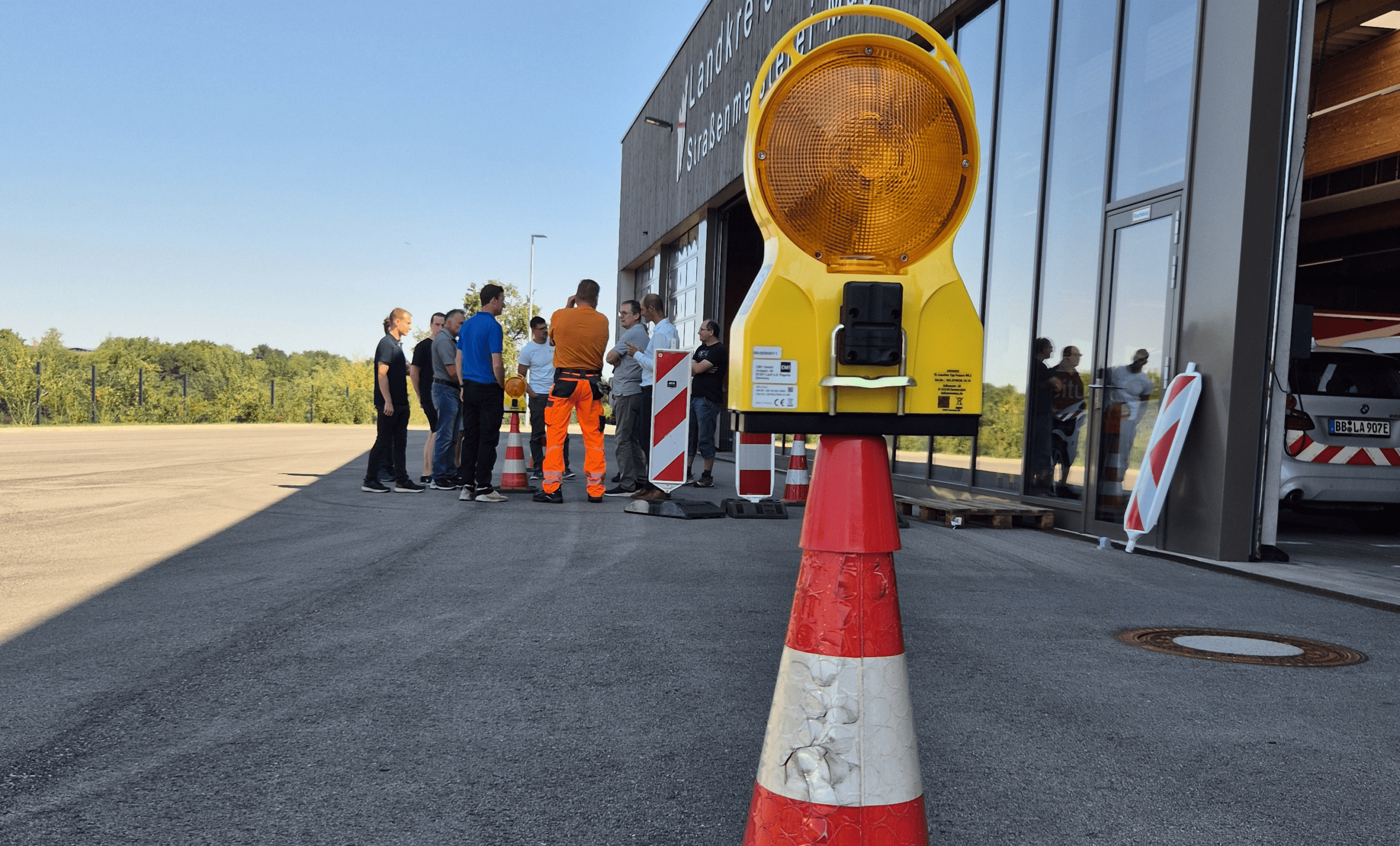 A group of project participants outside the Magstadt Road Maintenance Depot during a field trial of the smart roadworks warning light.
